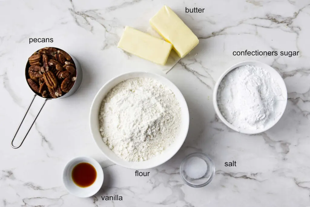 Ingredients used to make snowball cookies with pecans.