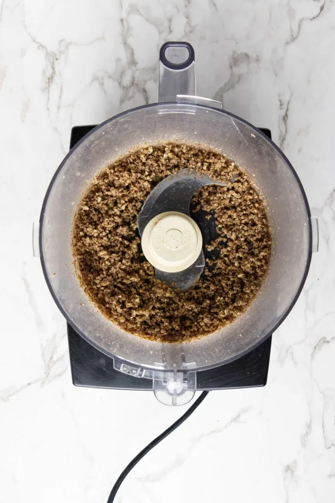 Blending pecans in a food processor.