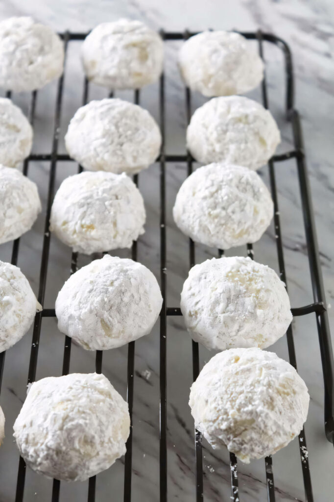 Mexican tea cookies on a cooling rack.