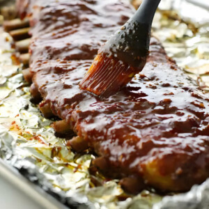 Brushing sweet and spicy bbq sauce on country style ribs.