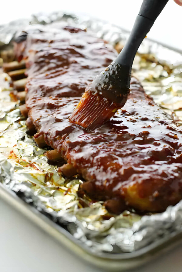 Brushing sweet and spicy bbq sauce on country style ribs.