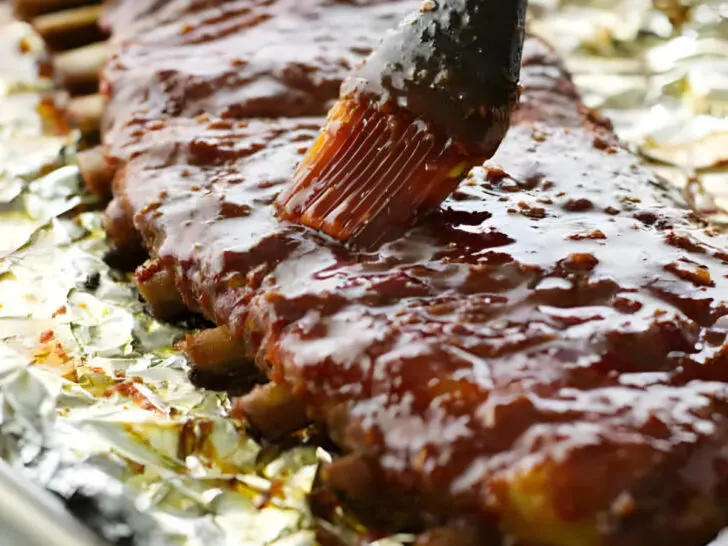 Brushing sweet and spicy bbq sauce on country style ribs.