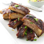 A plate with a stack of baby back Asian pork ribs.