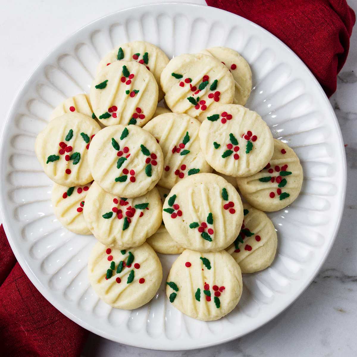 A plate filled with melt in your mouth whipped shortbread cookies.