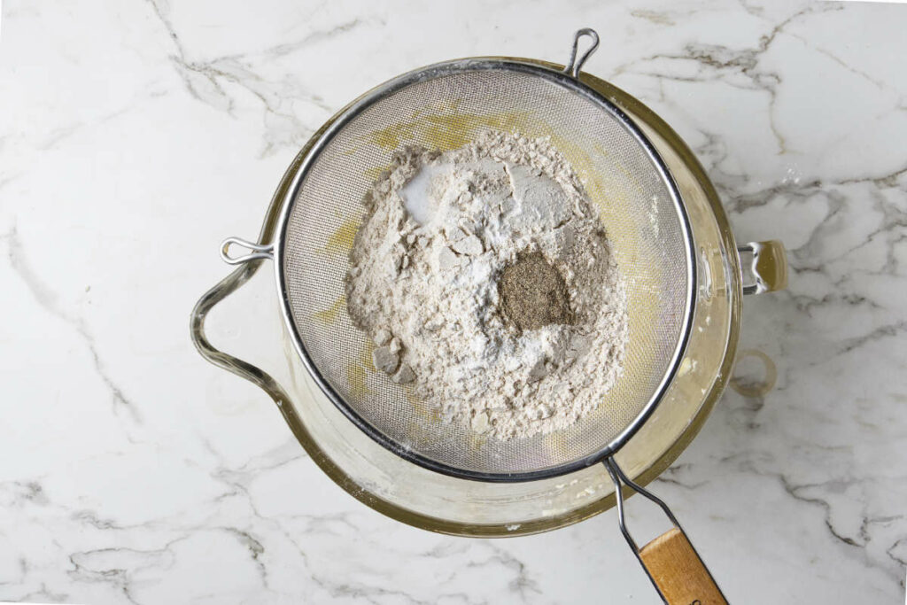 Sifting flour and spices into cookie dough.