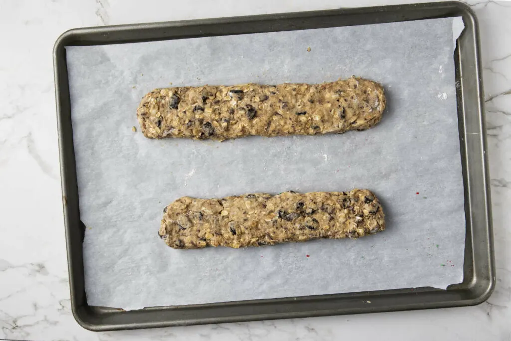 Biscotti dough shaped into logs on a baking tray ready for the oven.