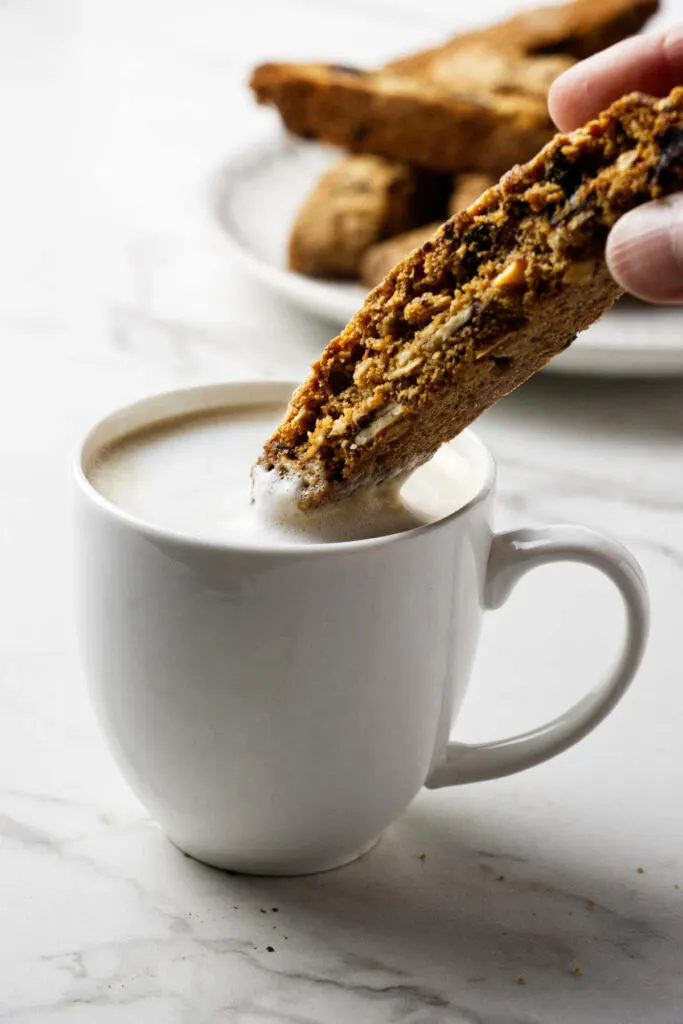 Dipping a biscotti into a cup of coffee.