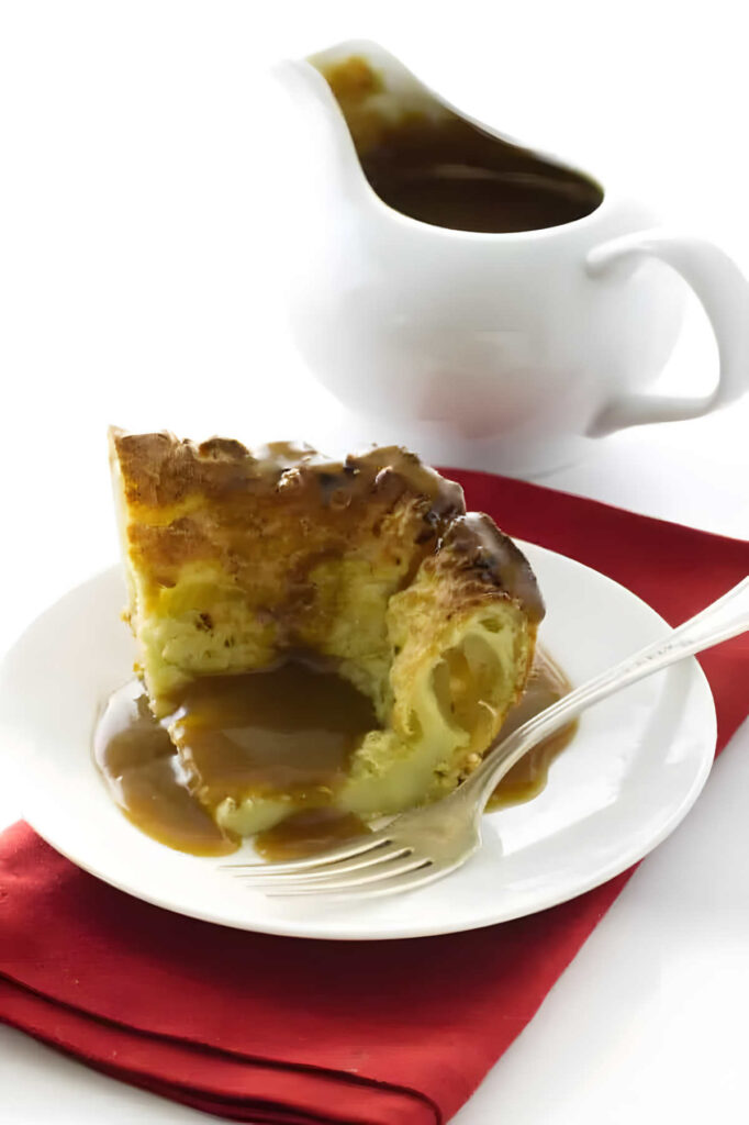 A serving of yorkshire pudding recipe with beef gravy and a gravy pitcher in the background.