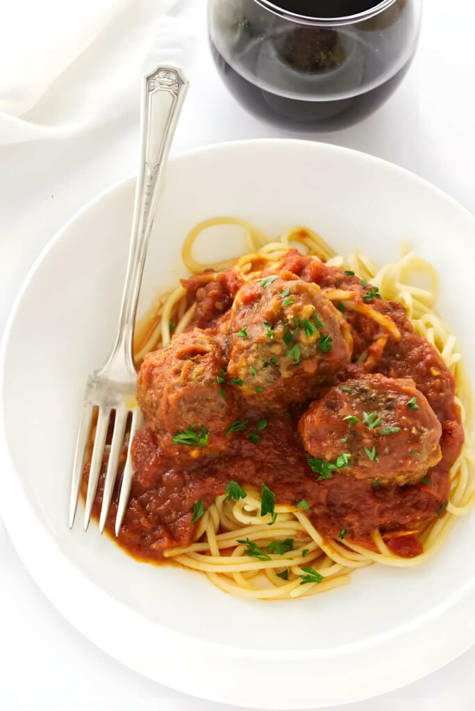 Meatballs and tomato sauce on a bed of spaghetti noodles.