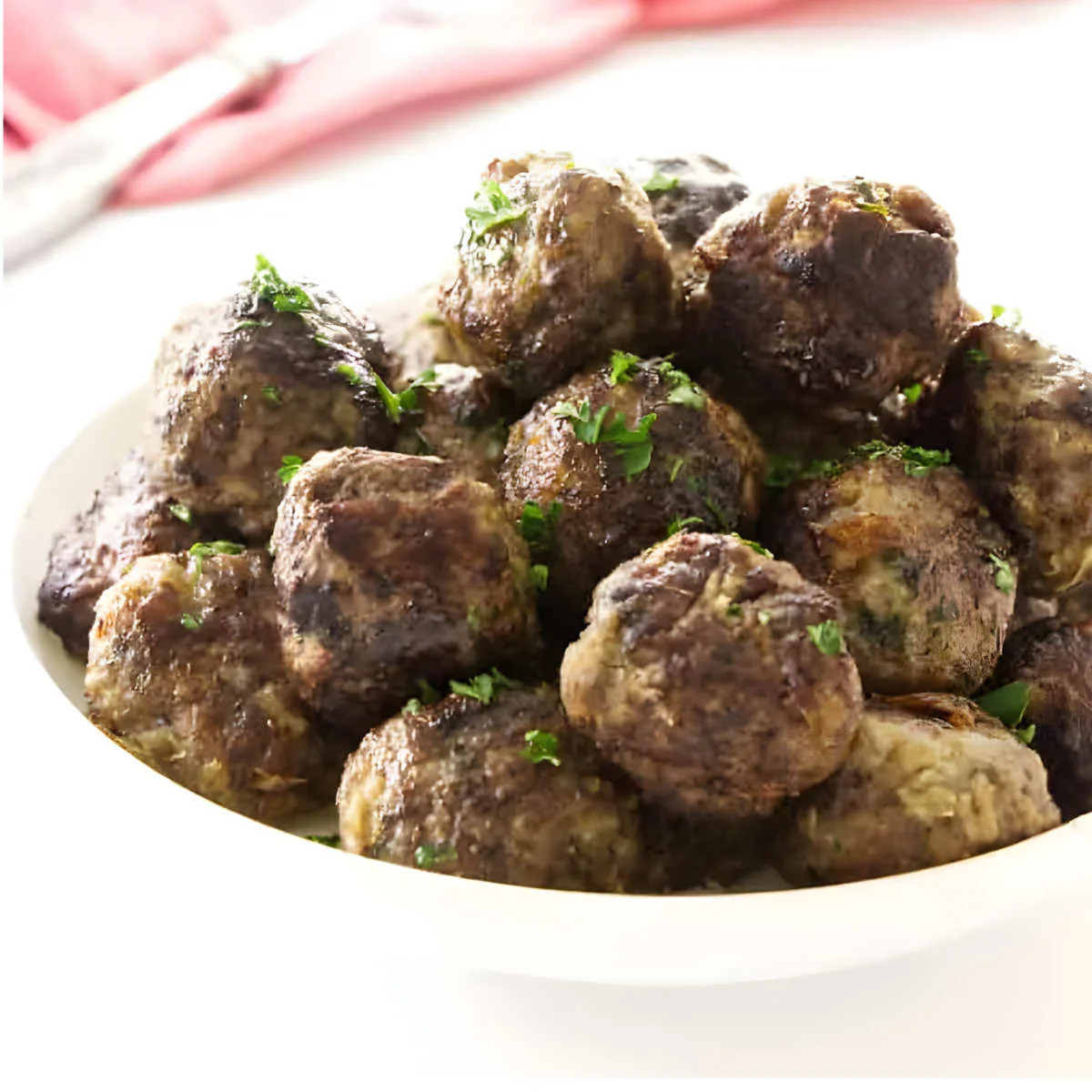 A bowl filled with beef and sausage meatballs.