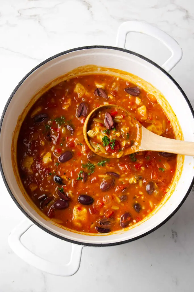 Rustic chicken soup with orzo, tomatoes olives.