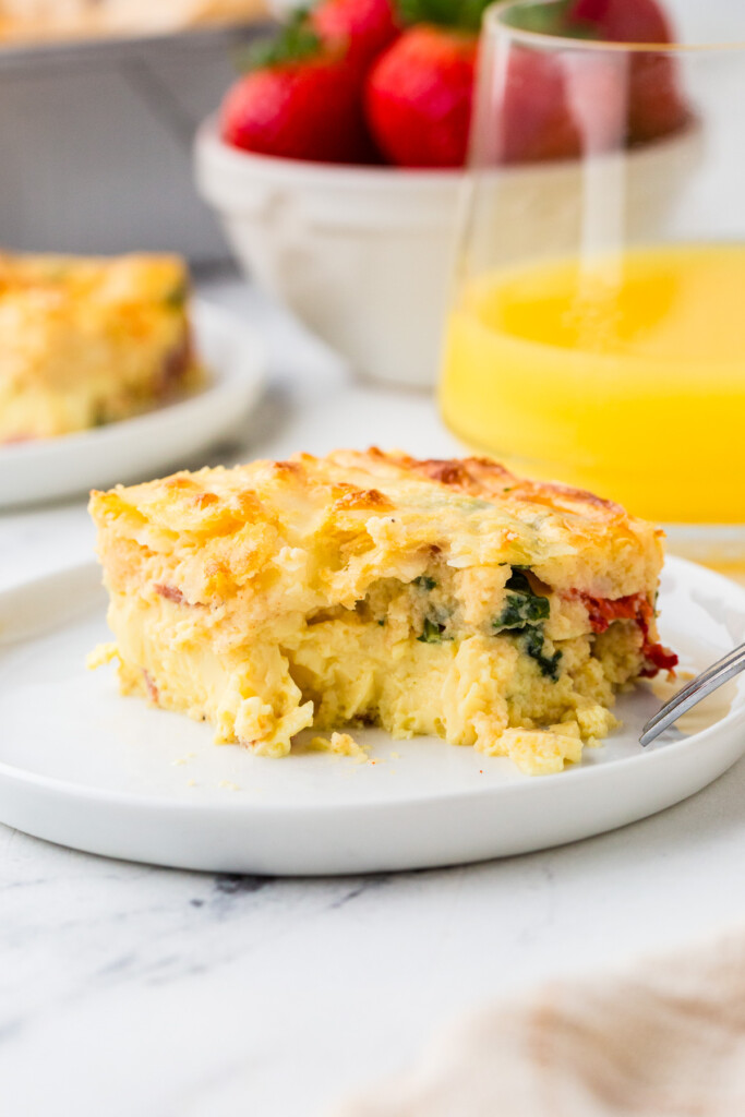 An egg bake recipe with cottage cheese in front of a glass of orange juice.