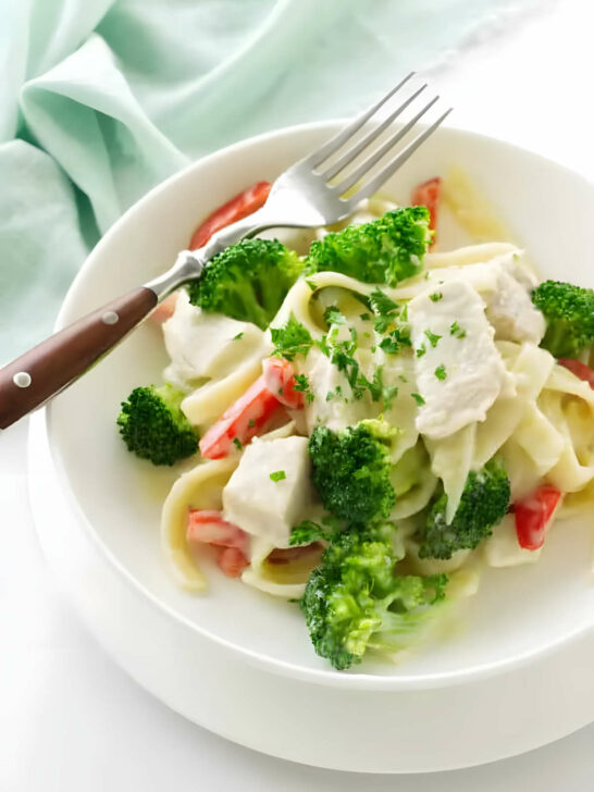 A bowl with chicken broccoli pasta in creamy sauce.