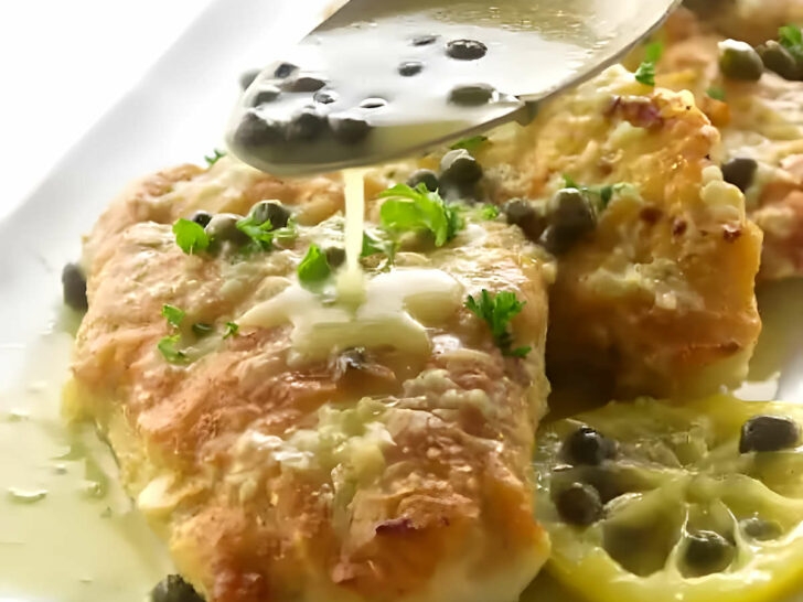 Drizzling lemon piccata sauce over pan fried chicken breast.