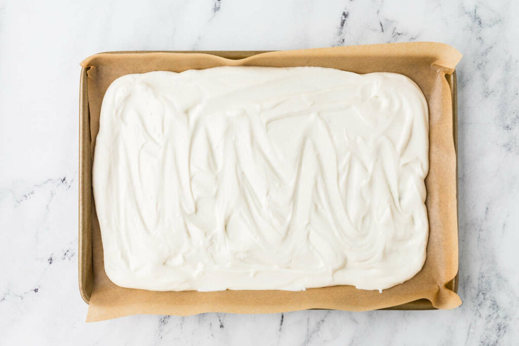 Spreading yogurt in a sheet pan lined with parchment.