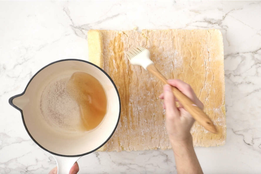 Spreading sugar syrup over the sponge for the strawberry yule log.