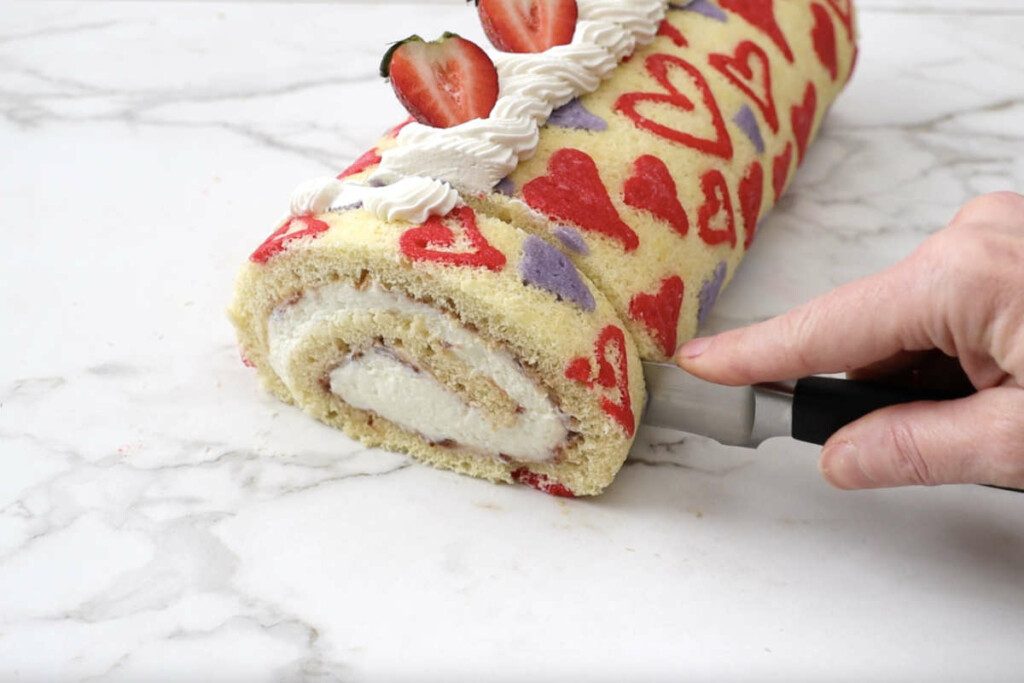 Slicing the Valentines patterned roll cake.