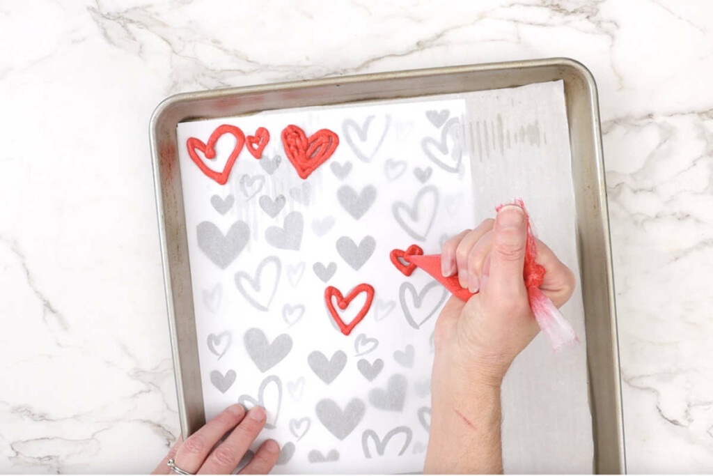 Piping heart patterns for a strawberry roll cake.