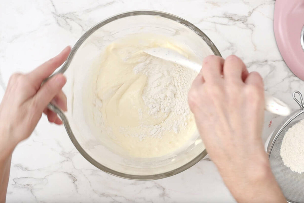 Folding flour into the batter for strawberry roll recipe.