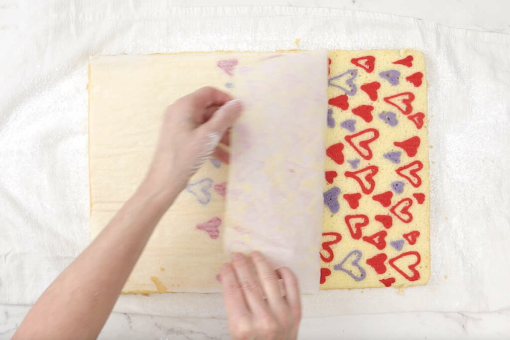 Pulling the parchment off the sponge to make decorated cake rolls.