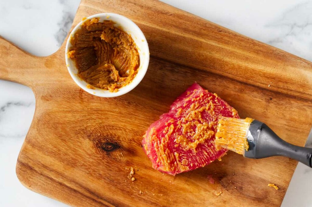 Seasoning a tuna steak for seared ahi tuna bowls.