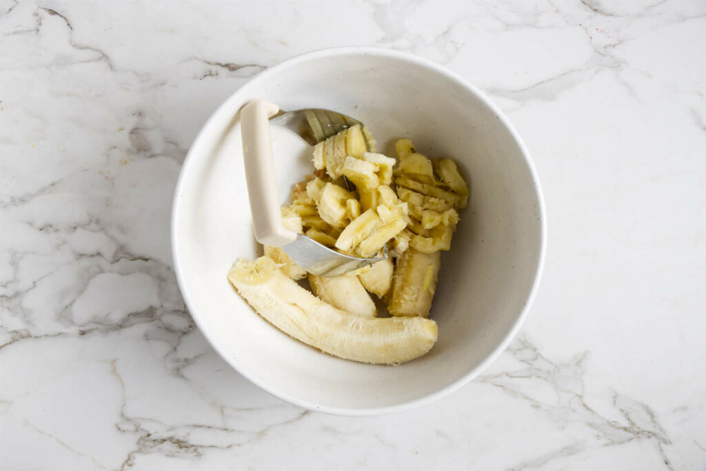 Mashing bananas in a bowl.