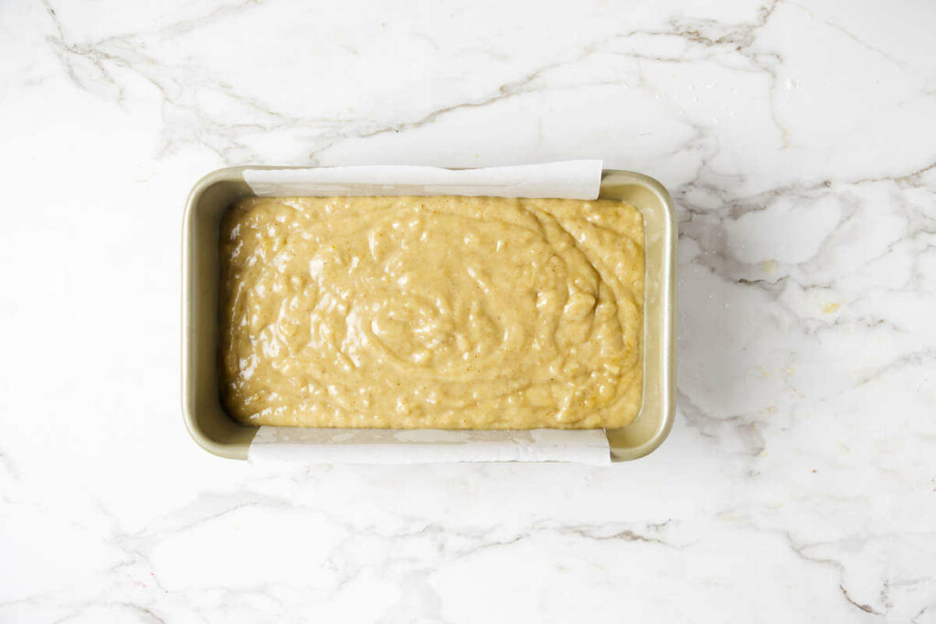 Spreading the sweet bread batter into a loaf pan.