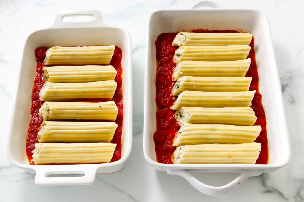 Separating the manicotti into two separate baking dishes.