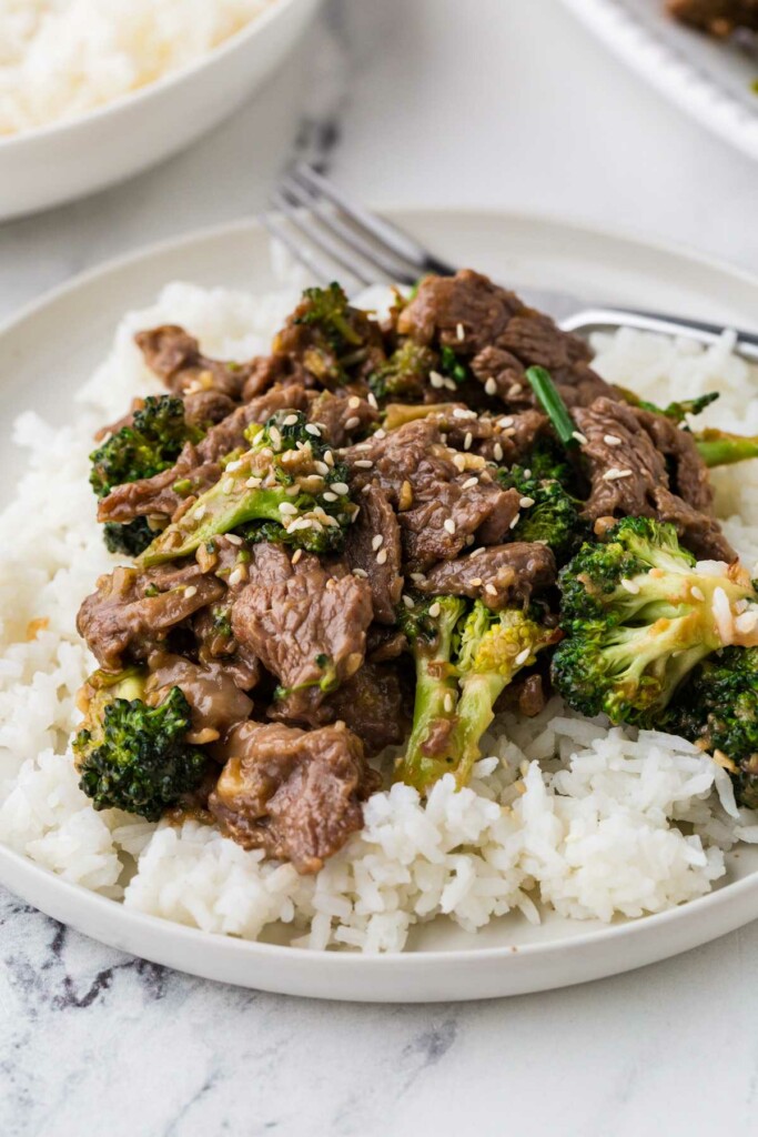 A serving of beef and broccoli stir fry on a bed of white rice.