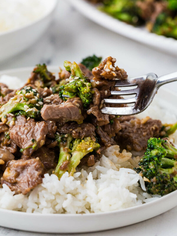 A fork taking a bite of beef and broccoli.