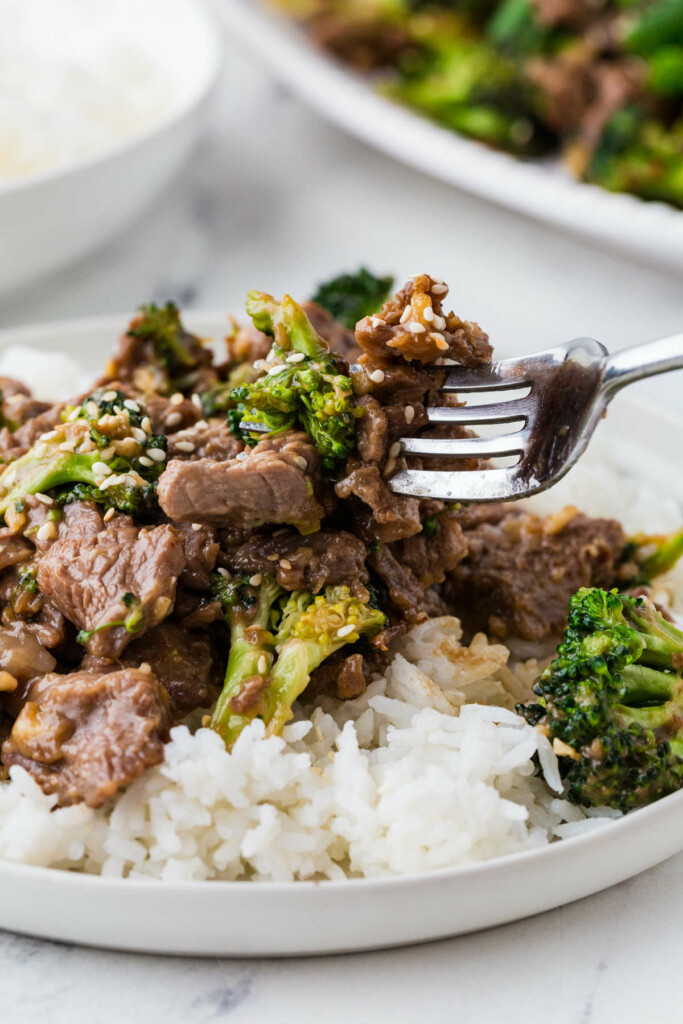 A fork taking a bite of beef and broccoli.