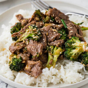 A serving of a beef and broccoli stir fry on a bed of rice.