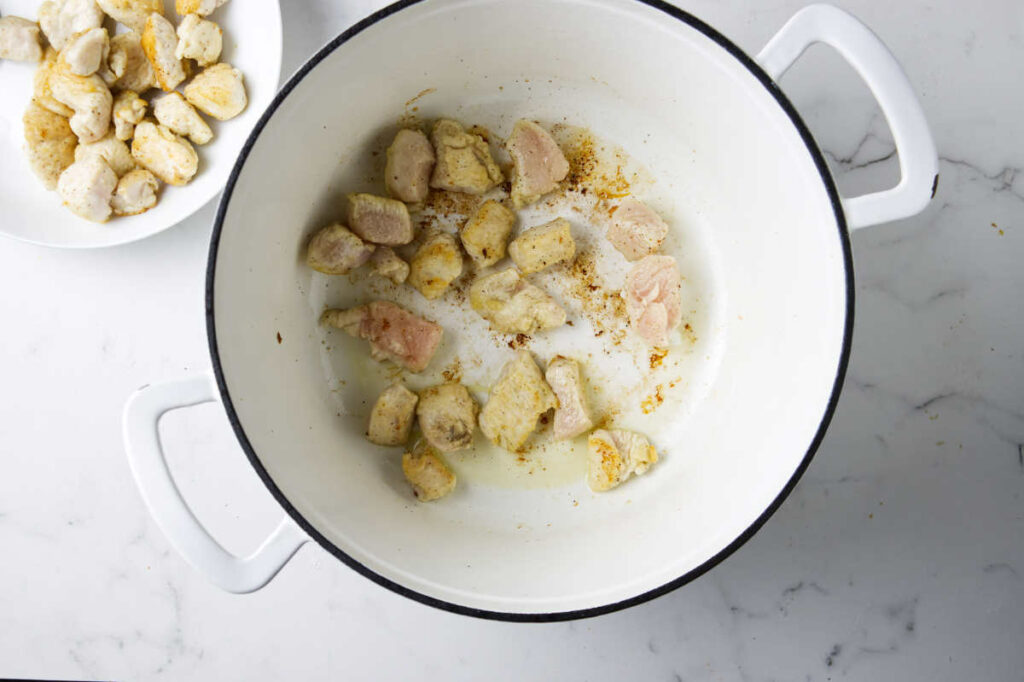 Browning the chicken in a pot.