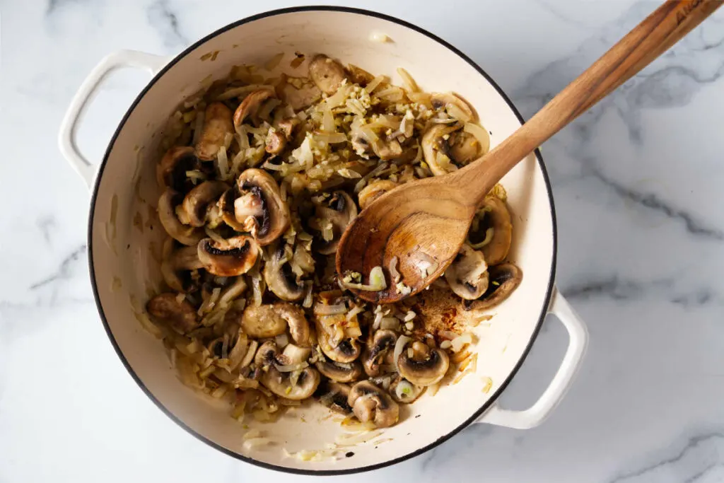 Sauteeing the mushrooms and onions.