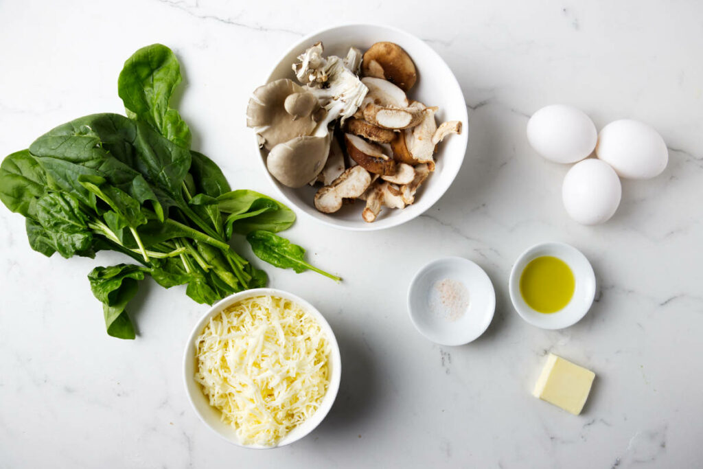 Ingredients used to make an egg white omelet with mushrooms and spinach.