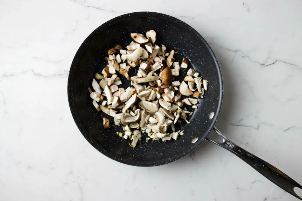 Cooking mushrooms in a saute pan.