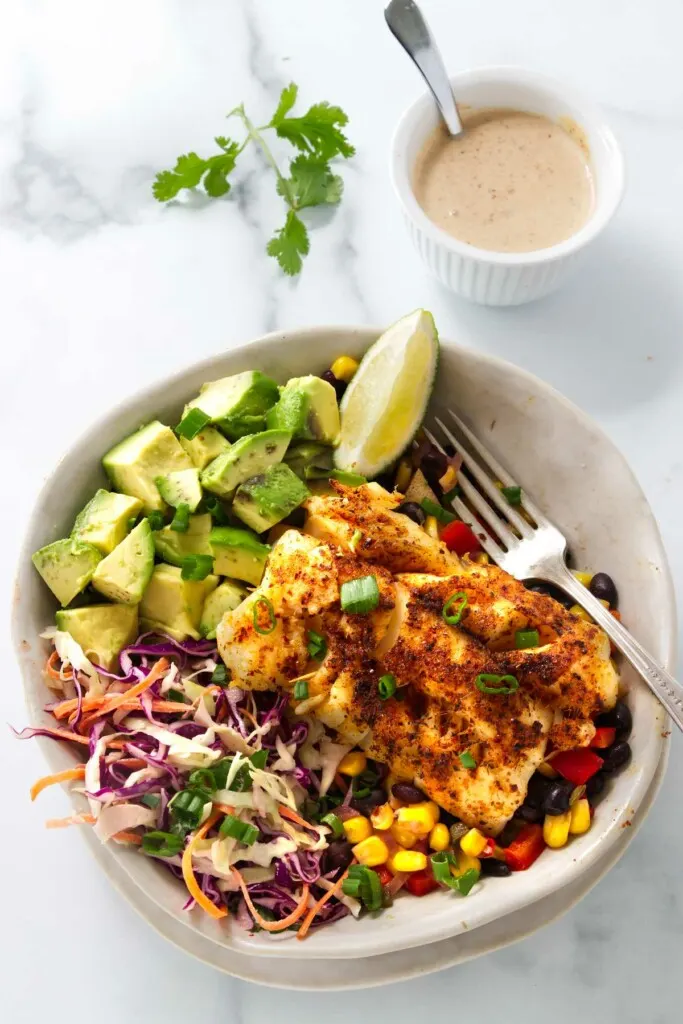 A fish taco bowl with corn and bean salsa.