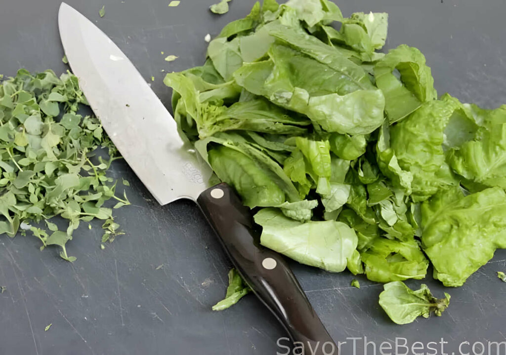 Chopping fresh basil to add to a pot of tomato sauce.