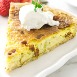 A slice of chevre quiche with a dollop of sour cream on top.