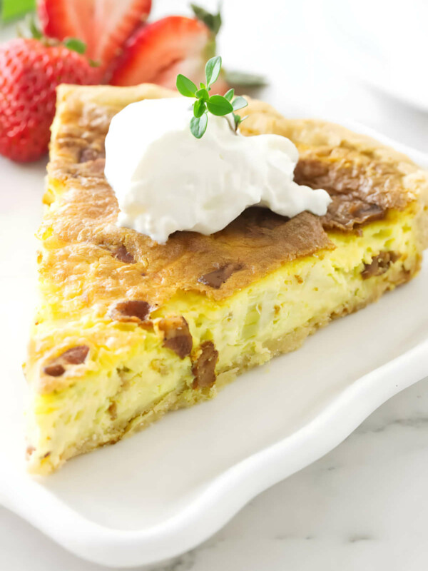 A slice of chevre quiche with a dollop of sour cream on top.