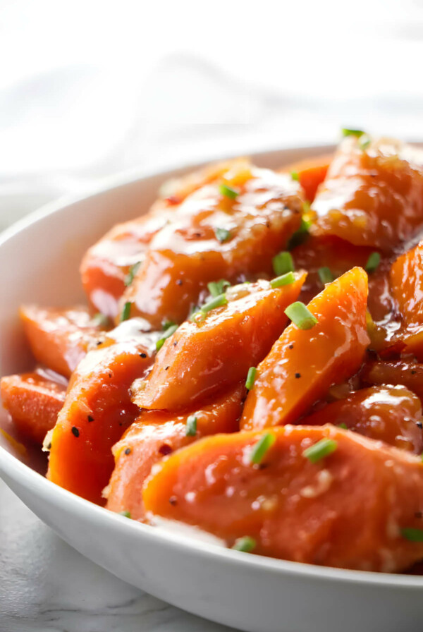 A serving bowl filled with instant pot honey glazed carrots.