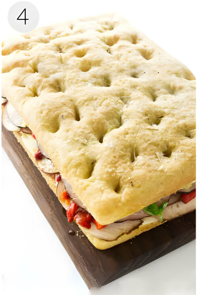 A large focaccia sandwich filled with Italian meats and condiments.