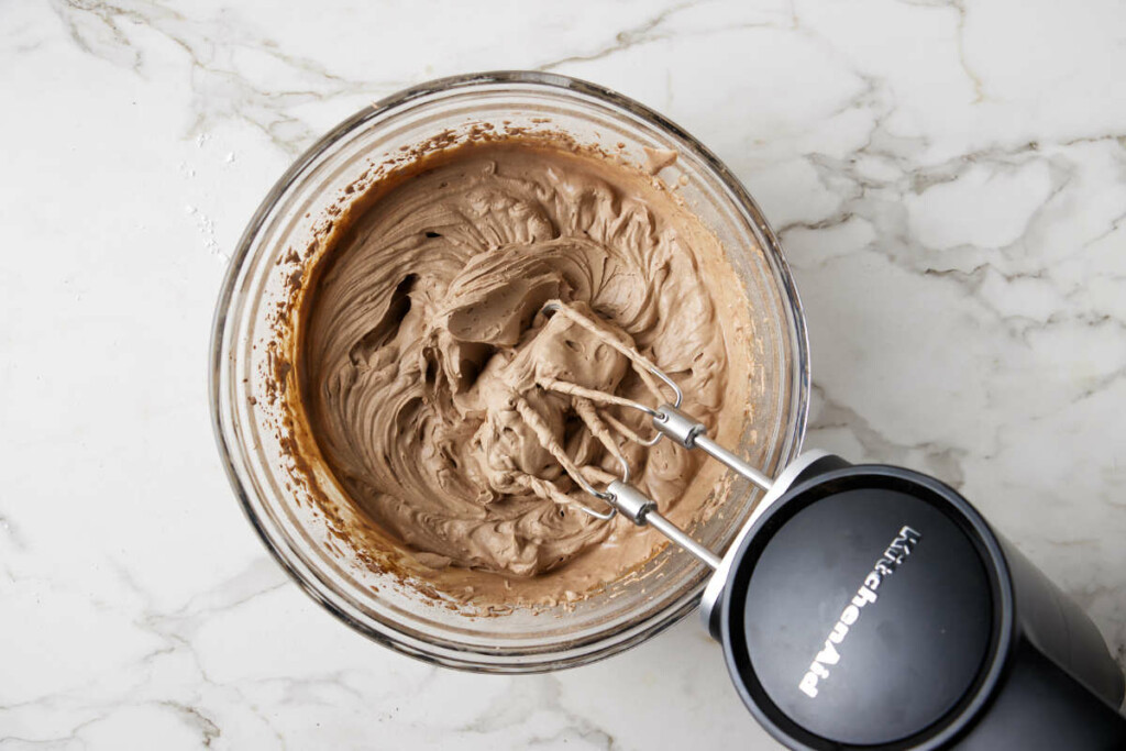 Whipping heavy cream with sugar and cocoa.