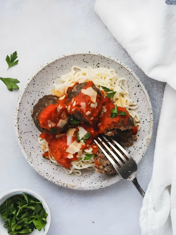 A dish filled with low carb noodles and keto meatballs with marinara sauce.