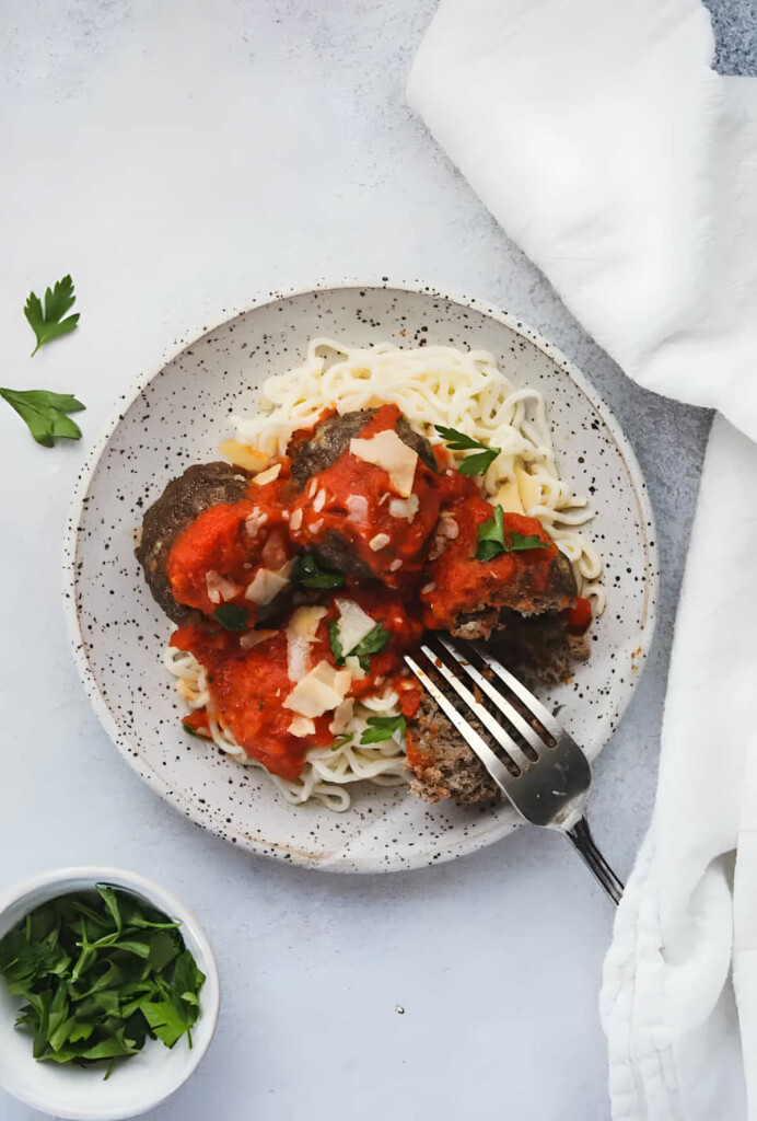 A dish filled with low carb noodles and keto meatballs with marinara sauce.