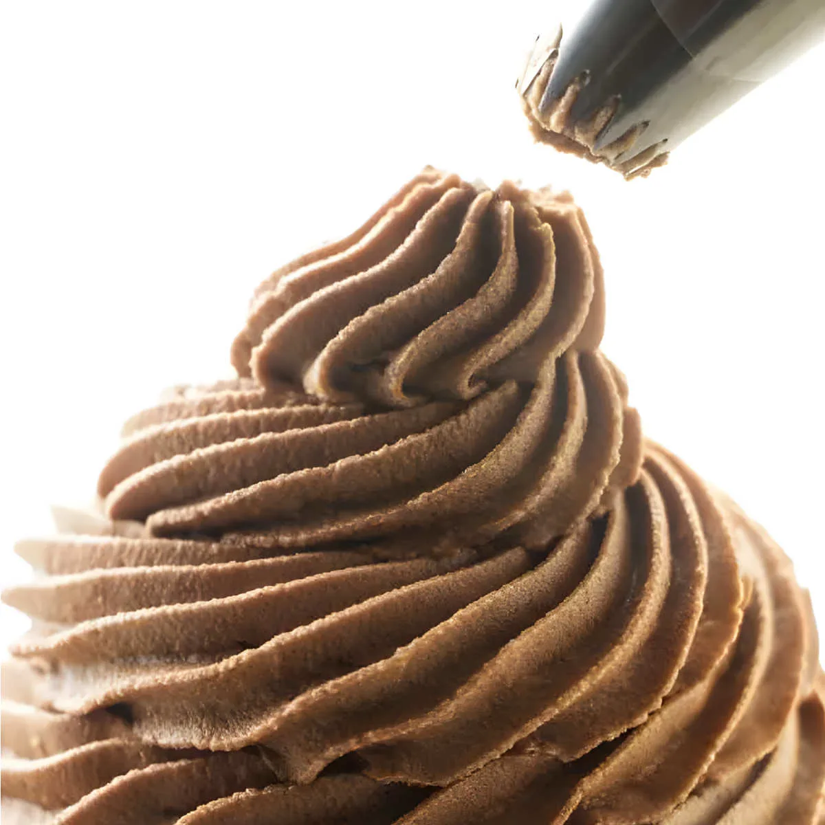 Piping nutella frosting on a cupcake.