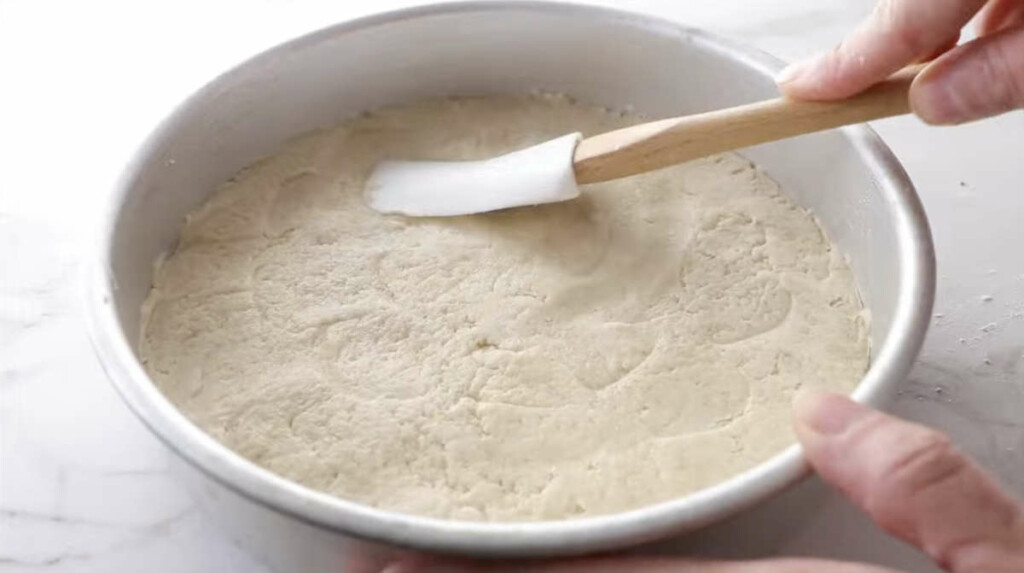 Spreading oatmeal shortbread cookie dough into a baking pan.