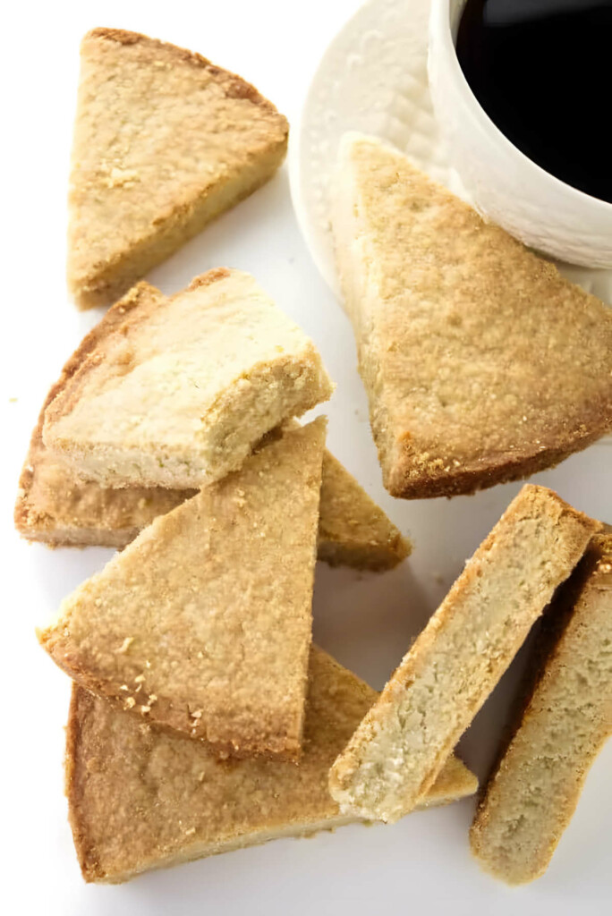 Slices of oatmeal shortbread cookie bars next to a cup of coffee.