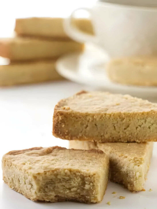 Three oat flour shortbread bars in front of a cup of coffee.