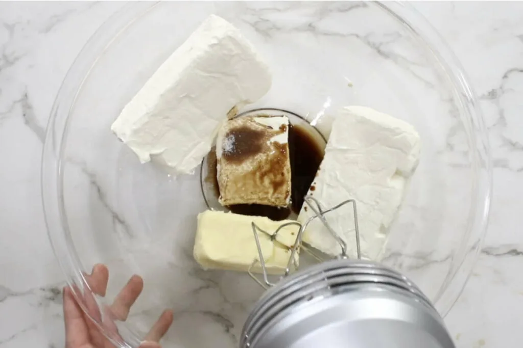 Mixing cream cheese and butter in a mixing bowl.